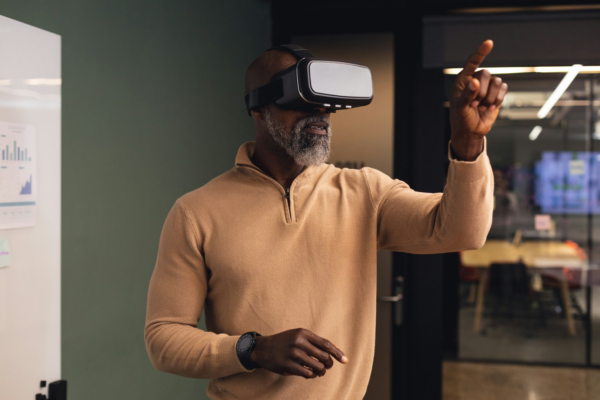 Functional neurology treatment | Mature african american businessman using virtual reality simulator pointing at creative office