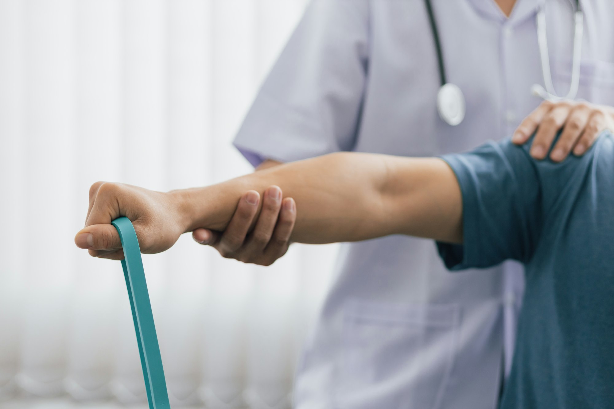 Physical therapists treat patients with exercises using latex therapy resistance band.